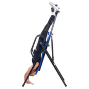 Inversinis stalas VELLOFIT 300 su žmogumi, atliekantis inversinę treniruotę, siekiant sumažinti nugaros skausmus.